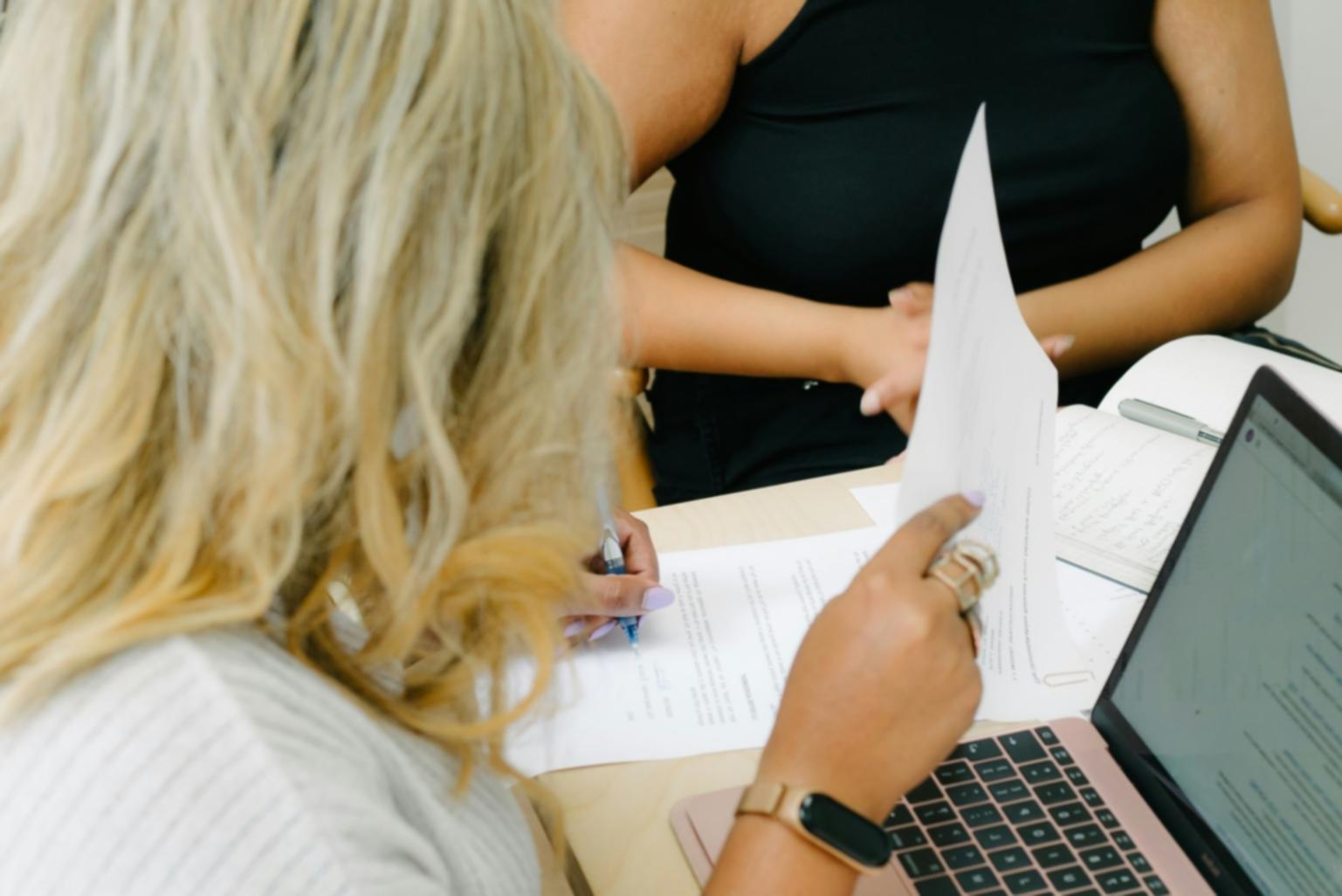 Personne travaillant sur son budget avec un ordinateur et des documents financiers